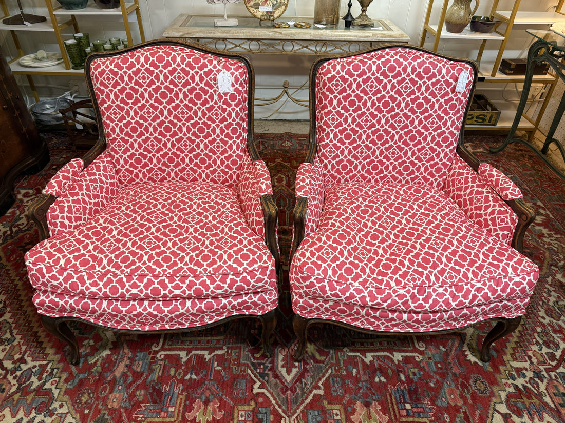 A classic French Bergère armchair with sculpted wooden frame and upholstered cushioned seat