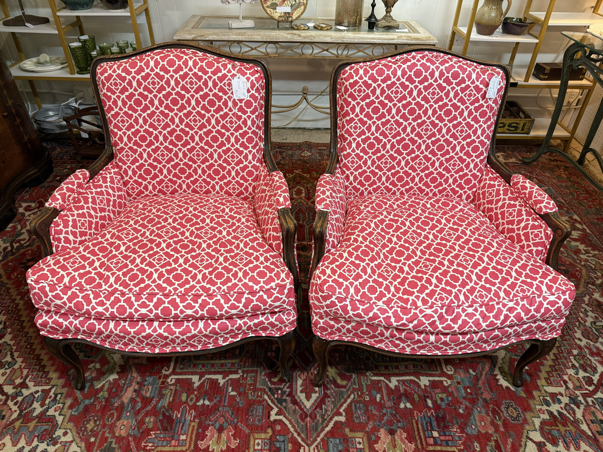 A classic French Bergère armchair with sculpted wooden frame and upholstered cushioned seat